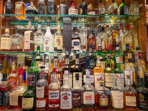 Back bar shelves stocked with whiskey, bourbon, rum and liqueur bottles