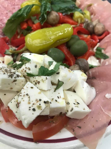 Close-up of antipasto with fresh mozzarella, pepperoncini, olives, roasted peppers and sliced ham