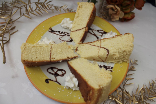 Slices of sponge cake on a yellow plate with chocolate drizzle and whipped cream