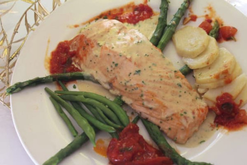 Pan-seared salmon fillet in cream sauce with asparagus, green beans and sliced potatoes